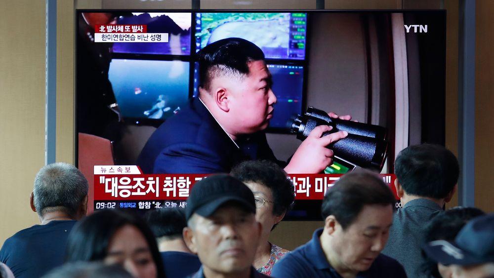 Folk ser på en TV som viser den nordkoreanske lederen Kim Jong Un under et nyhetsprogram på jernbanestasjon i Seoul, Sør-Korea, tirsdag 6. august, 2019. Tirsdag skjøt Nord-Korea uidentifiserte prosjektiler to ganger i sjøen.